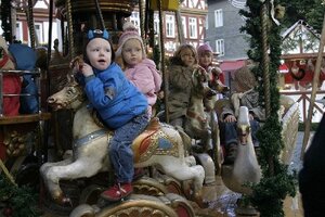 Kinder fahren mit dem Karussell am Marktplatz