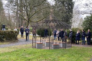 Menschen stehen auf dem Friedhof Herborn zur Widmung des Gedenkplatzes für Sternenkinder