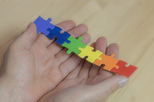 Hände mit bunten Puzzleteilen